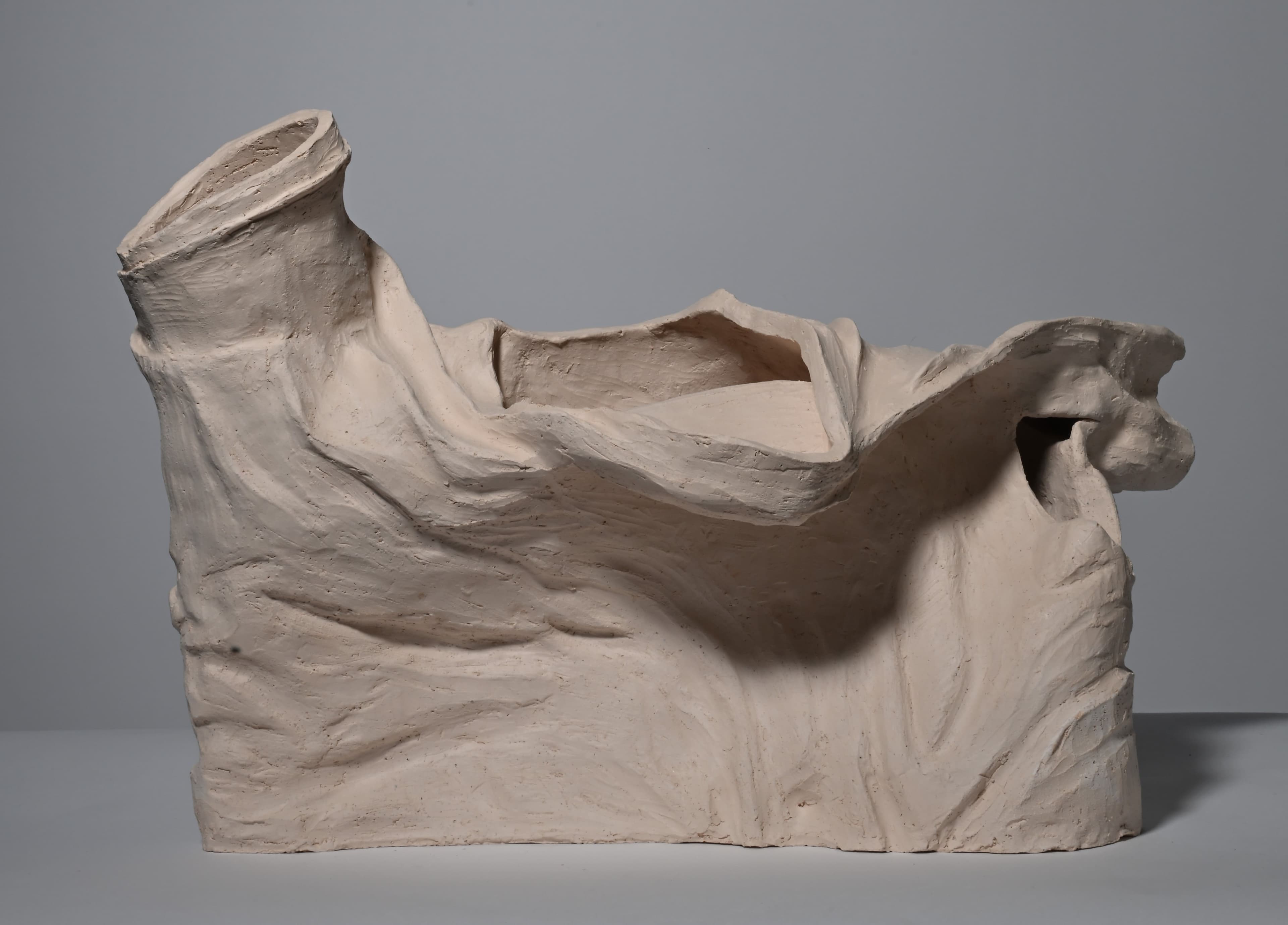 clay sculpture in the shape of wrinkled shirt, bisque fired, front view