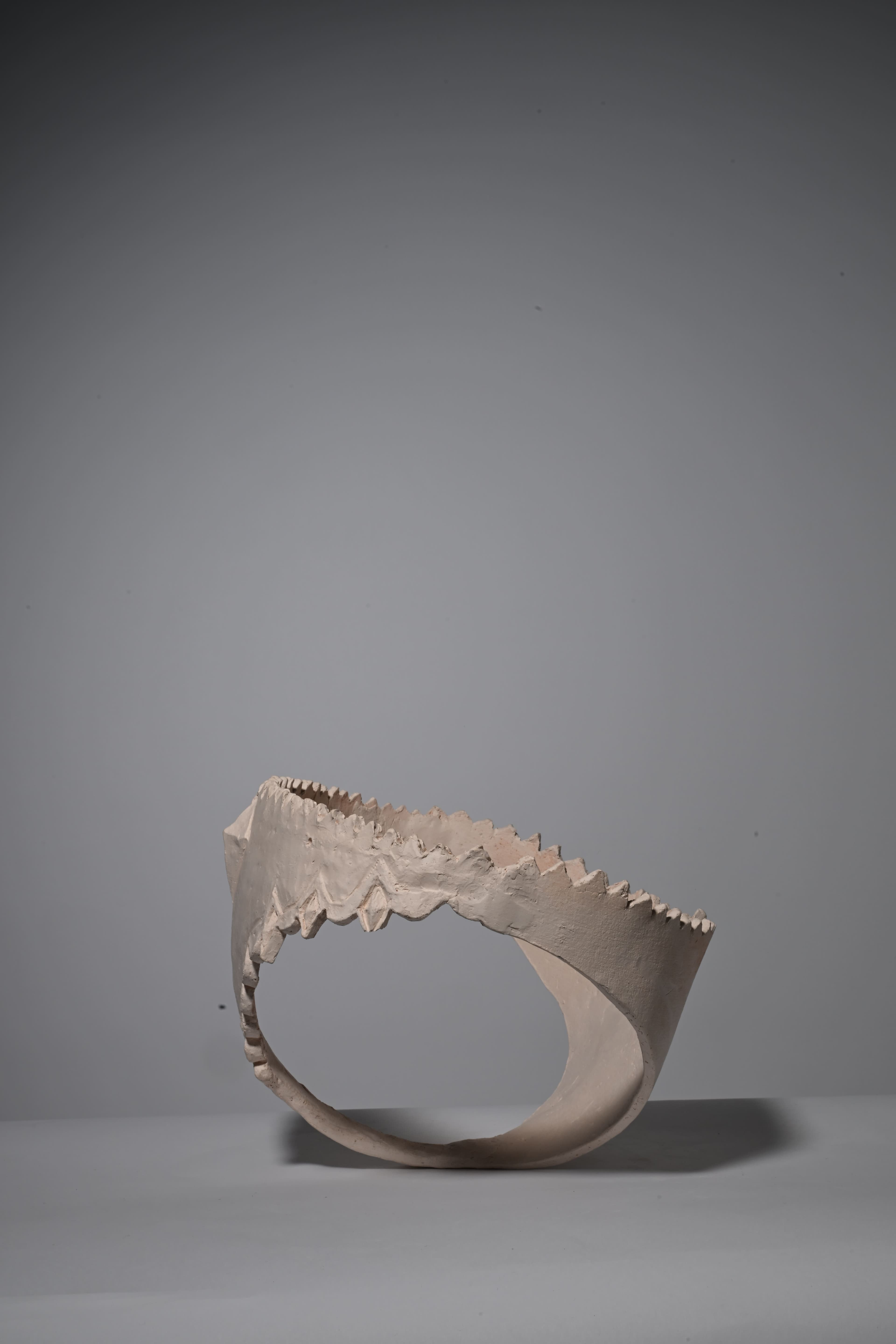 image of clay sculpture in the shape of underwear,bisque fired, side view